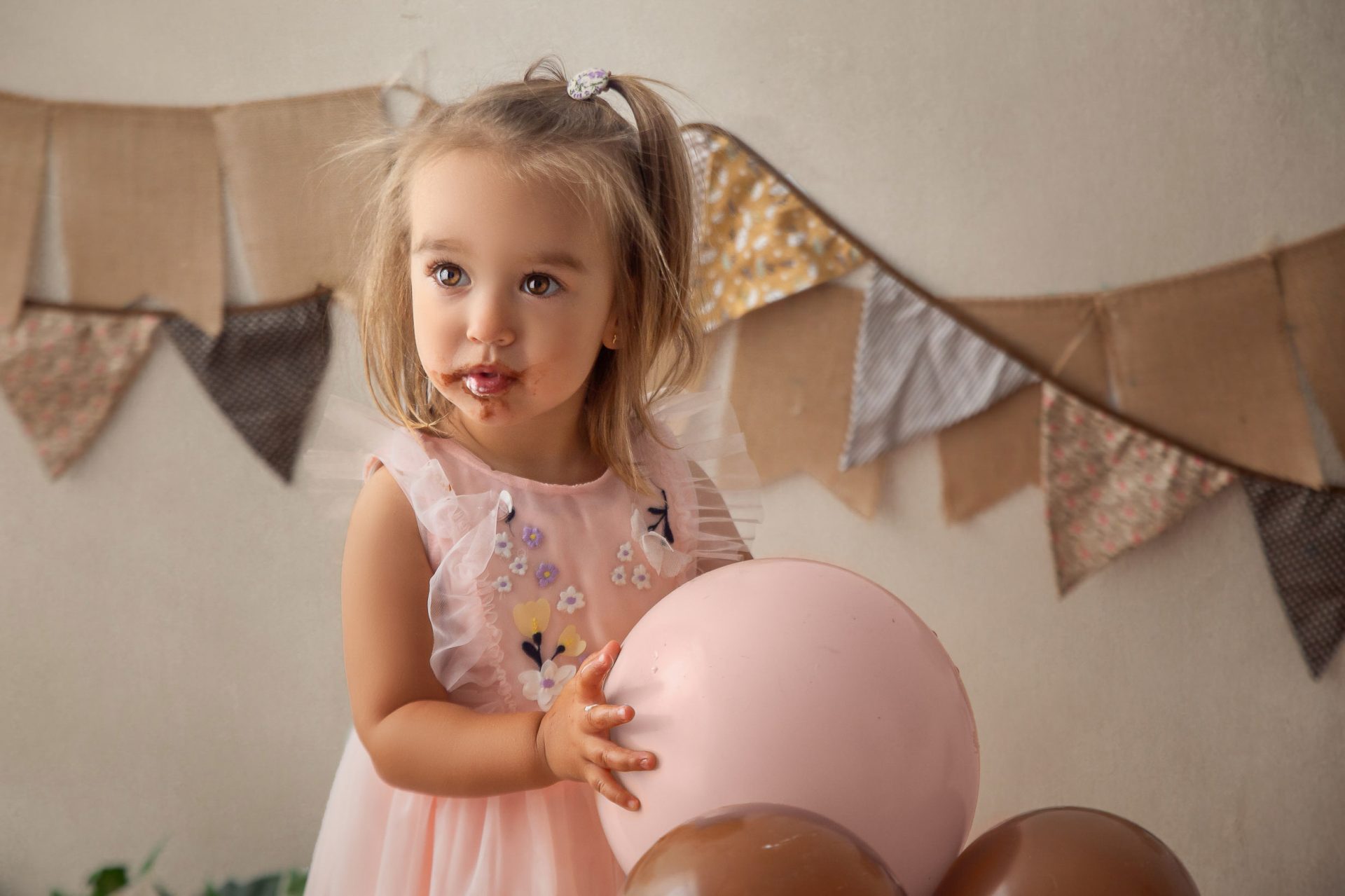 fotografía-infantil-bilbao-smash-cake-2 Niña en sesión smash cake de 2 años con decoración en tonos rosas
