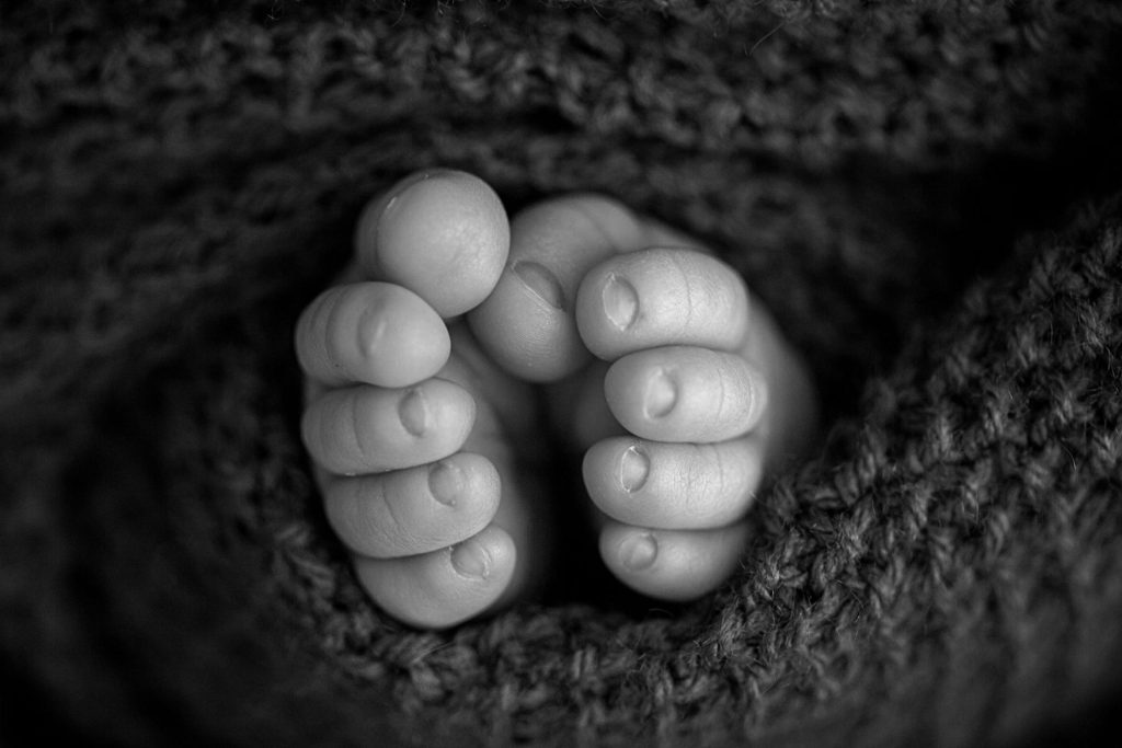 Pies diminutos del bebé envueltos en manta suave