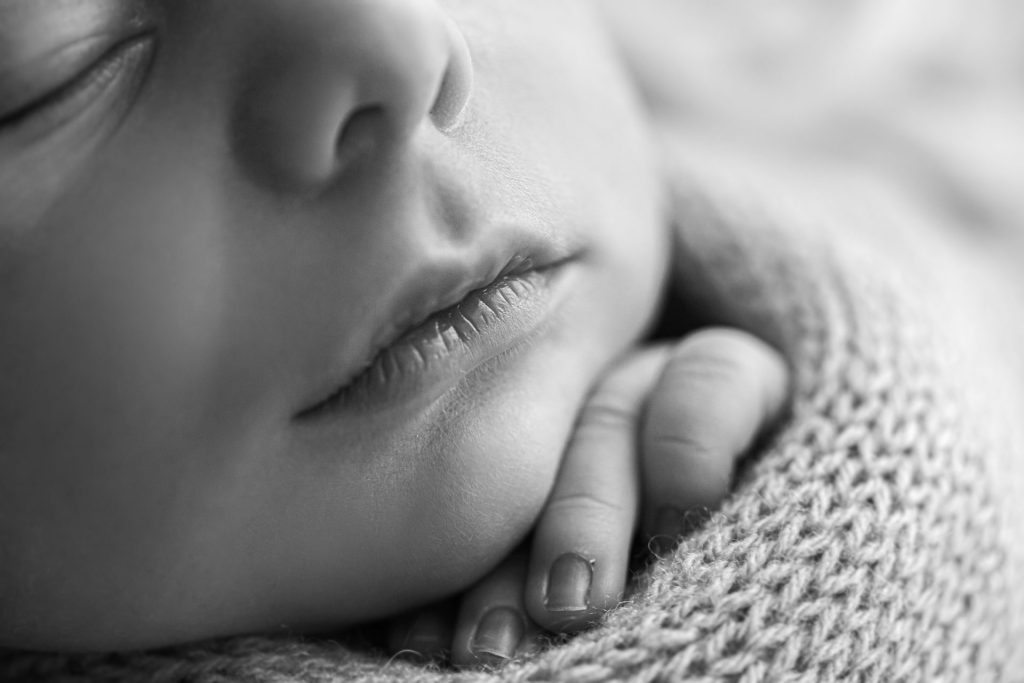 Retrato en blanco y negro delicado de recién nacido con detalles naturales