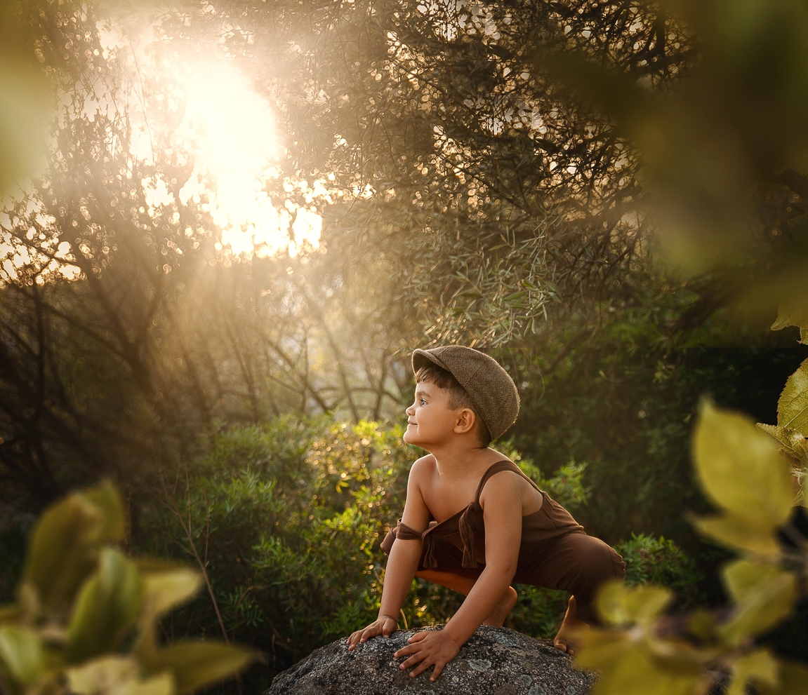sesión-de-fotos-de-bebés-en-Barakaldo-fotografías-emotivas Escena infantil en Bilbao, niño con gorra vintage jugando entre la hierba