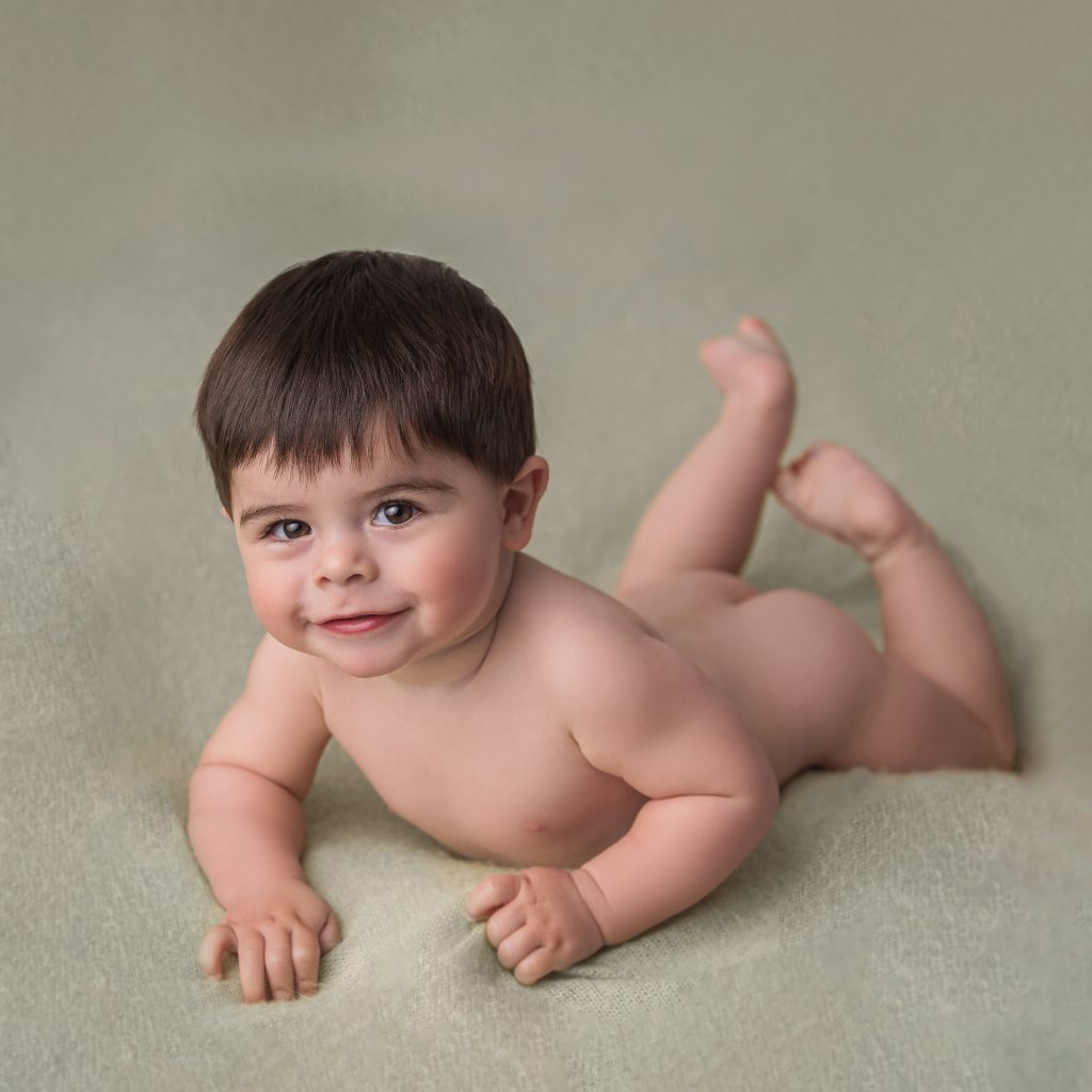 retrato simpático de bebe de 8 meses sobre fondo verde